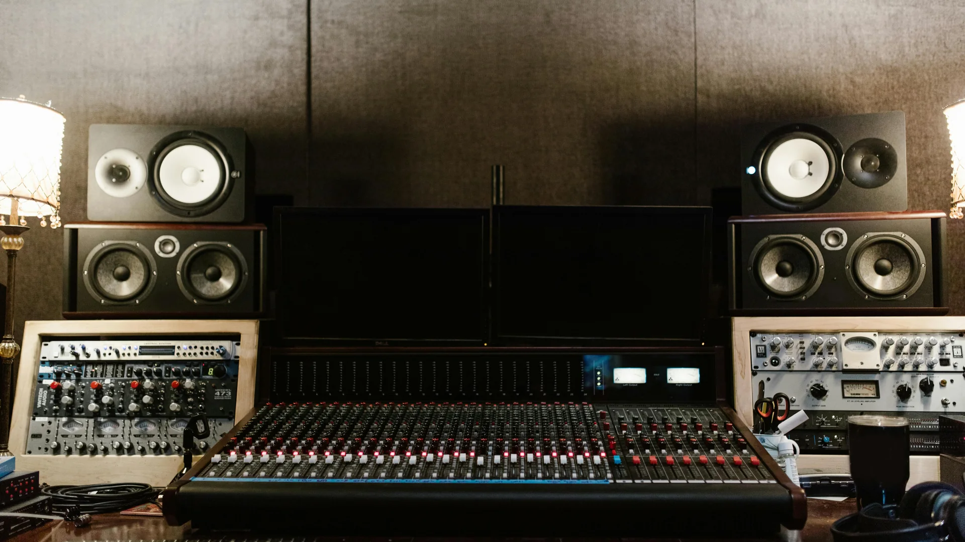 A treated recording studio control room with monitor speakers and acoustic panels.